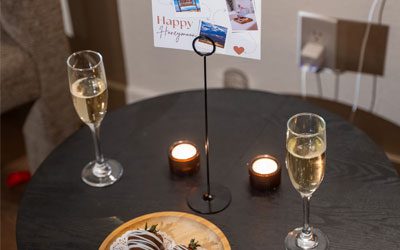 Maria-Spa4 A table set with two glasses of champagne, lit candles, and chocolate-covered strawberries