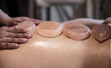 Maria-Spa9 Image of Himalayan salt stones being placed on a client's back.