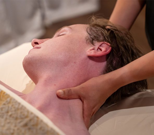 single-massage A man receiving a massage on his neck by a therapist