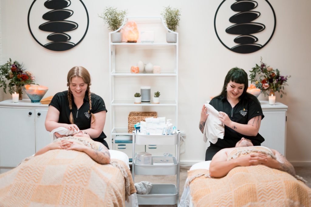 Two guests receiving side-by-side spa treatments at Zen'd Out