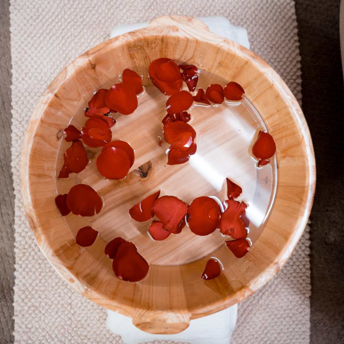 Rose petals in a wooden foot bath at Zen'd Out