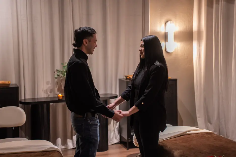 A couple holding hands in a private couples suite at Zen'd Out