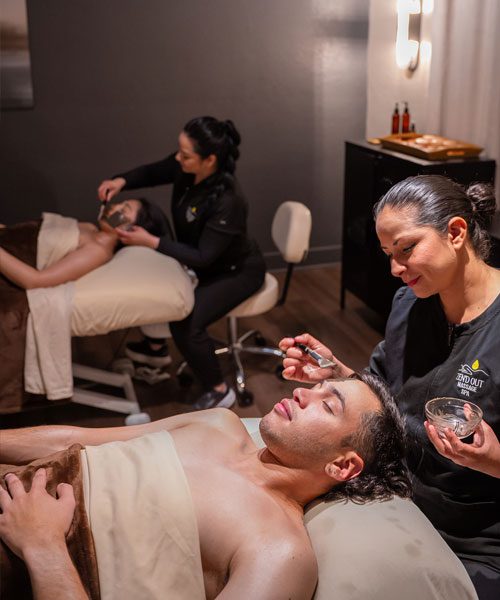 Two guests receiving simultaneous facial treatments at Zen'd Out